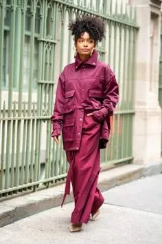 Woman in a burgundy oversized utility jacket and matching trousers on a street