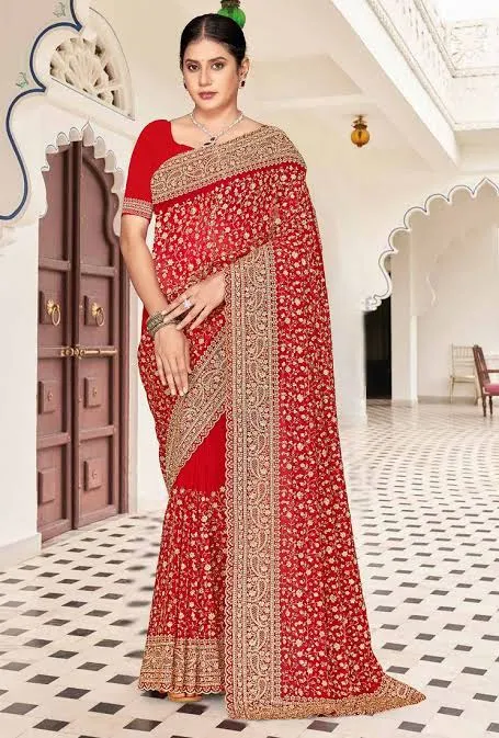Woman in a red embroidered sari beneath a scalloped archway