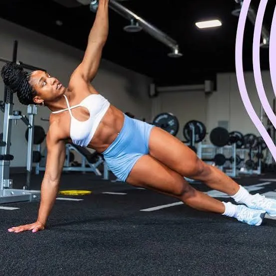 Woman holding a side plank in a gym
